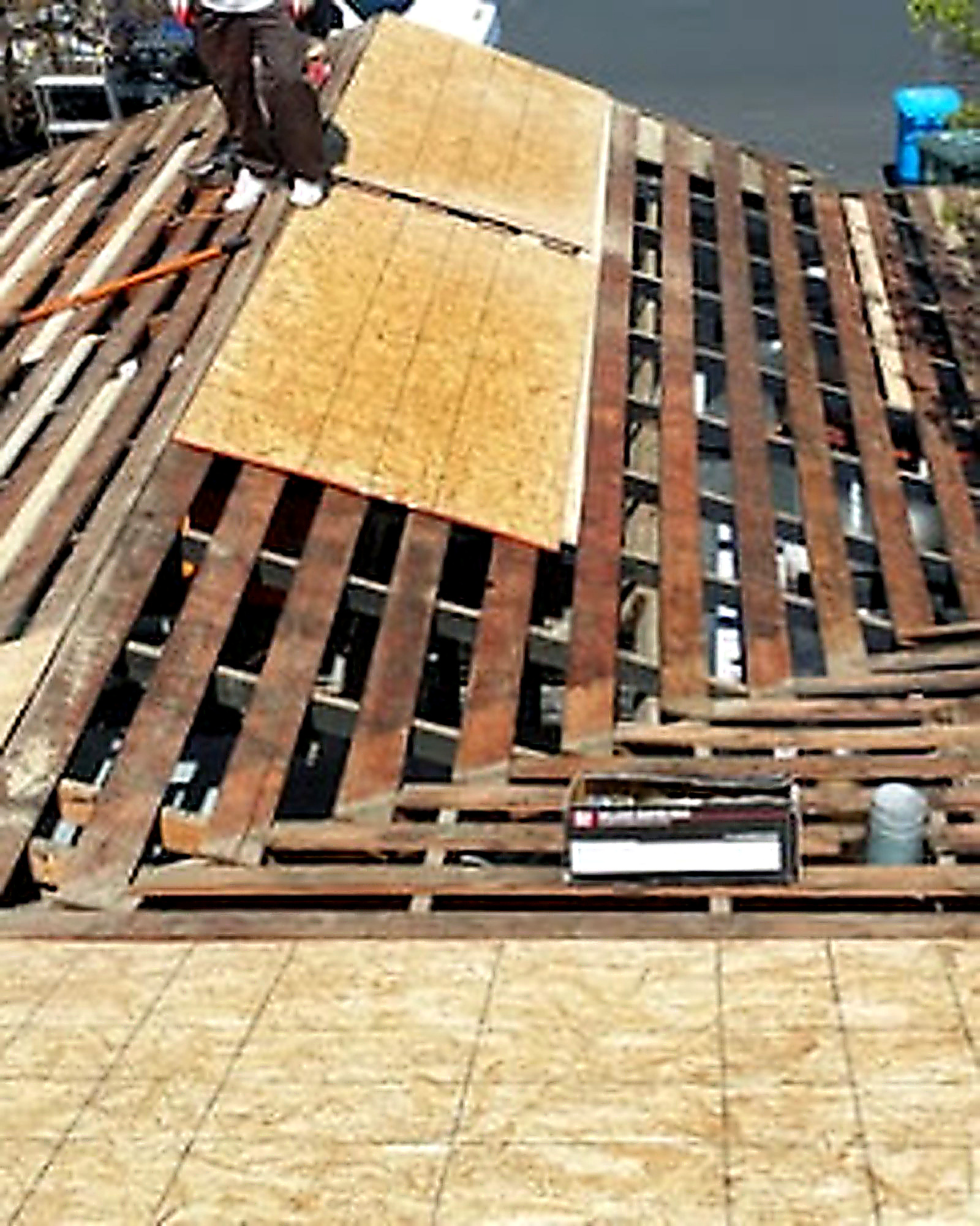 Roof deck replacement showing exposed framing and new OSB sheathing