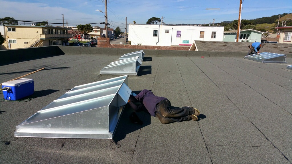 New galvanized skylight curbs installed on a flat roof in San Francisco
